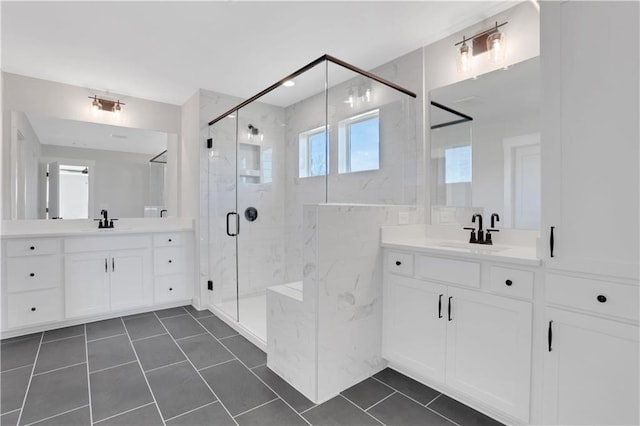 bathroom with two vanities, a sink, and a marble finish shower