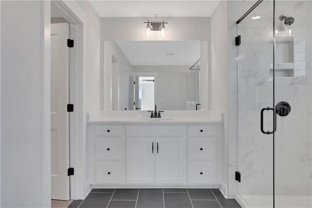 full bath featuring a stall shower, vanity, and tile patterned floors