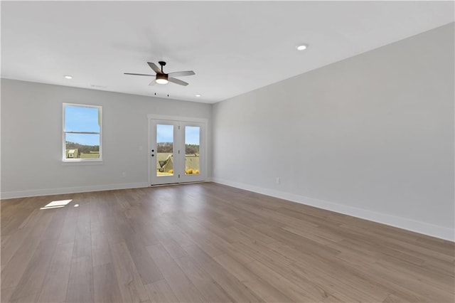 empty room featuring recessed lighting, ceiling fan, light wood-style flooring, and baseboards