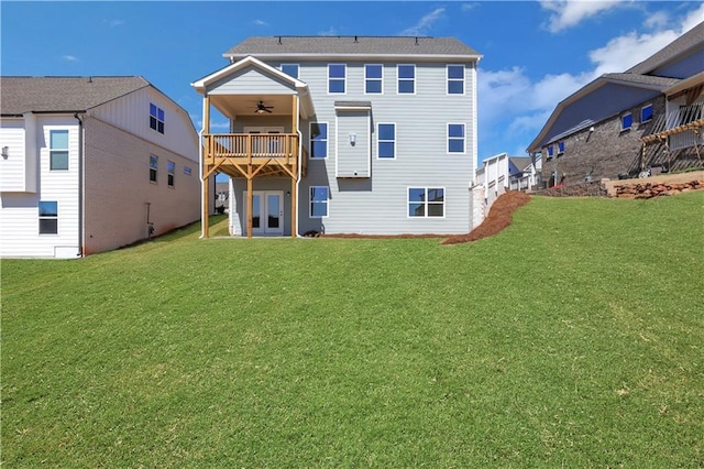 back of property featuring ceiling fan and a yard