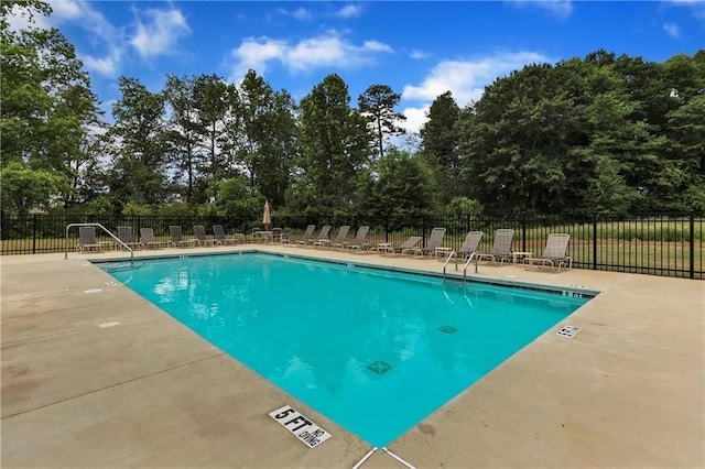 pool featuring fence and a patio