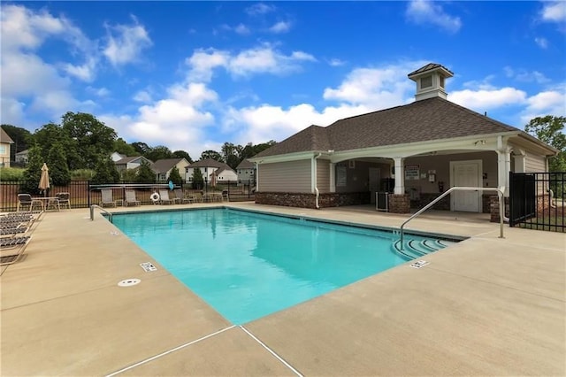 pool with a patio area and fence