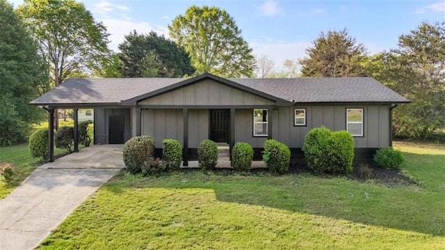 ranch-style home with concrete driveway, a carport, board and batten siding, and a front yard