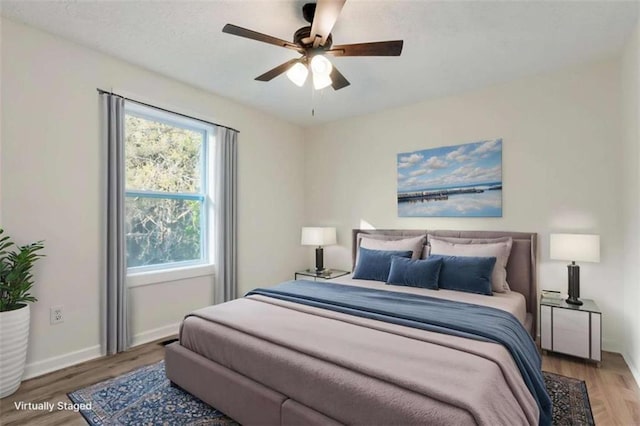 bedroom featuring wood finished floors, baseboards, and ceiling fan