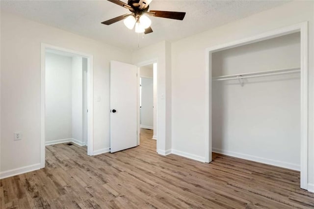 unfurnished bedroom with wood finished floors, a closet, and baseboards
