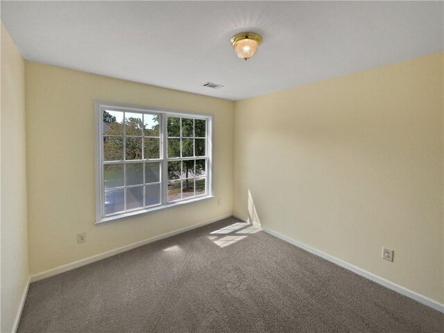 carpeted empty room with baseboards and visible vents