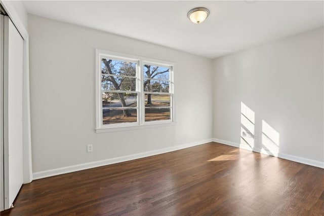 unfurnished bedroom with a closet and dark wood-type flooring