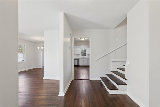 foyer with dark hardwood / wood-style flooring and a notable chandelier