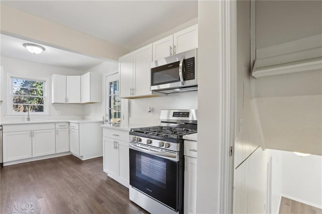 kitchen featuring stainless steel appliances, white cabinetry, dark hardwood / wood-style floors, and sink