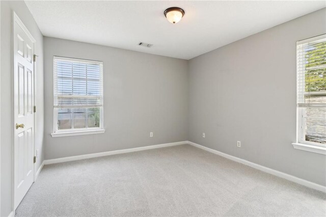 empty room with baseboards, carpet flooring, and visible vents