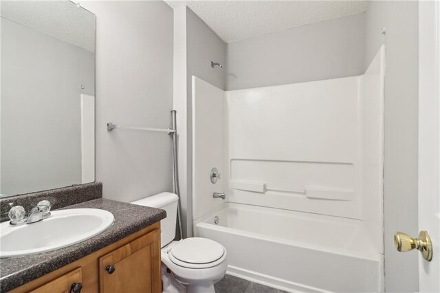 full bath featuring a textured ceiling, tile patterned flooring, vanity, toilet, and tub / shower combination