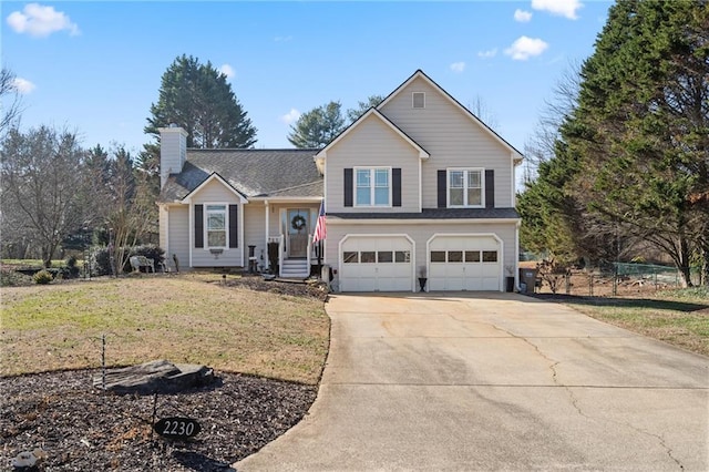 tri-level home with an attached garage, fence, driveway, a chimney, and a front yard