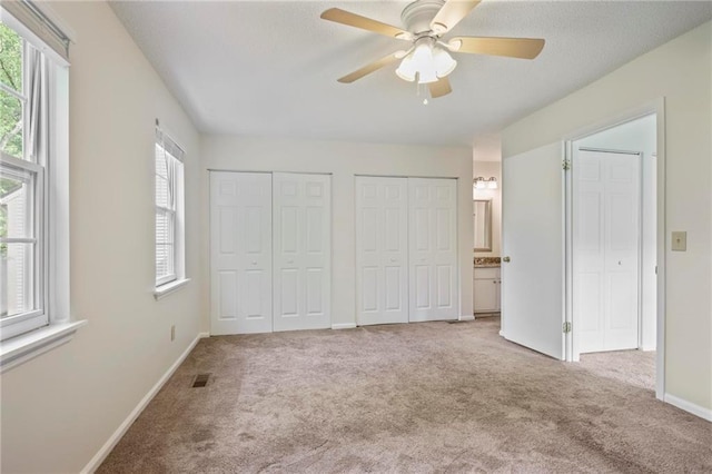 2117 Bucktrout Pl, Dunwoody, GA 30338 - unfurnished bedroom with carpet flooring, two closets, baseboards, ensuite bathroom, and ceiling fan