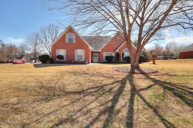 view of front of property featuring brick siding and a front lawn