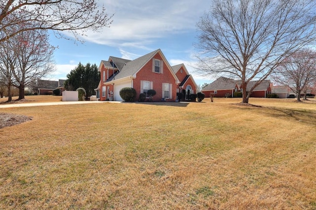 view of side of property with a garage, a yard, and brick siding