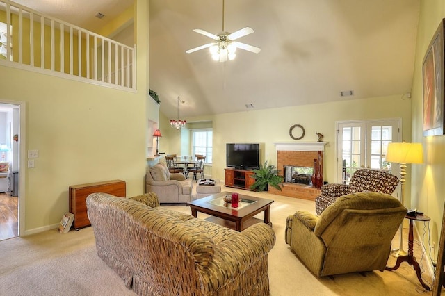 living room with carpet floors, a fireplace, visible vents, a towering ceiling, and ceiling fan