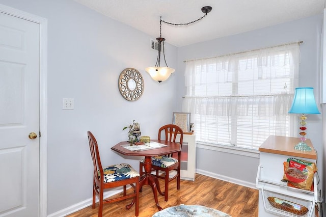 dining space featuring plenty of natural light, baseboards, and wood finished floors