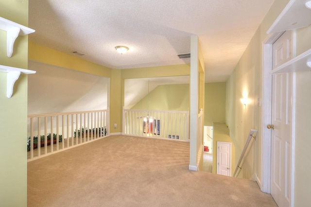 interior space featuring a textured ceiling, carpet flooring, and visible vents