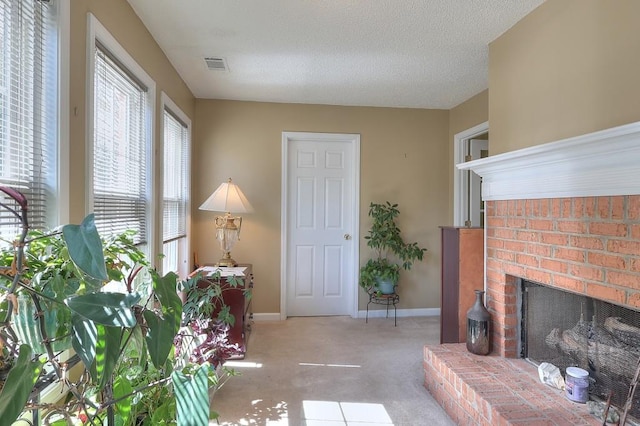 carpeted living room with baseboards, a fireplace, visible vents, and a textured ceiling