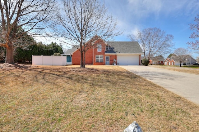 view of front facade with brick siding, concrete driveway, a front yard, fence, and a garage