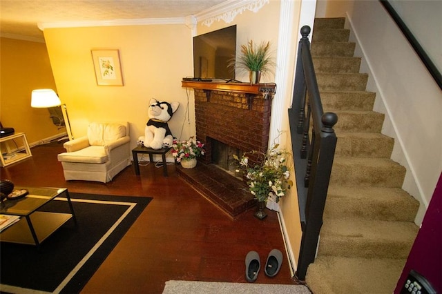 living room with crown molding, hardwood / wood-style flooring, and a brick fireplace