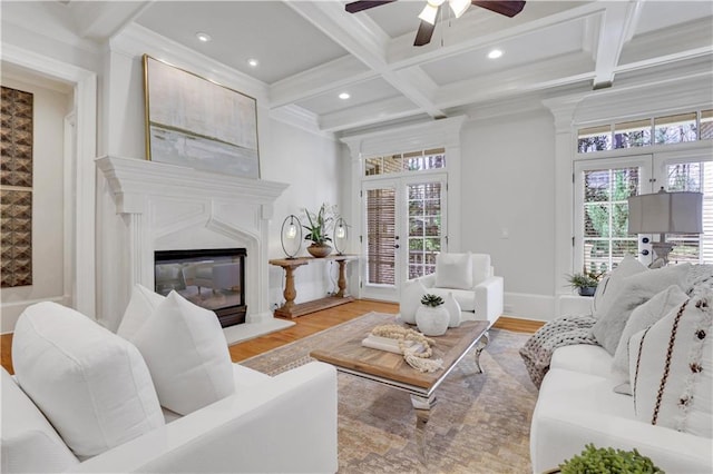 living room featuring french doors, coffered ceiling, wood finished floors, and a fireplace