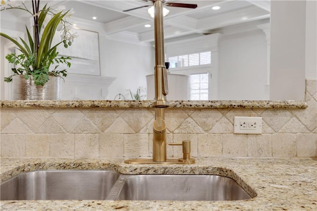 kitchen featuring a sink, beamed ceiling, coffered ceiling, and light stone countertops