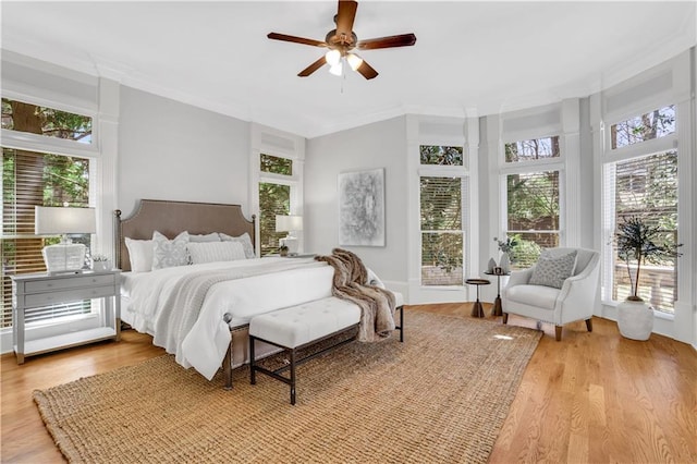 bedroom featuring crown molding, multiple windows, and wood finished floors