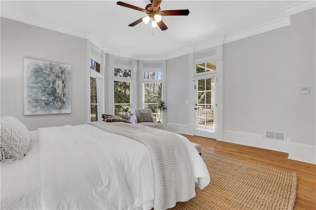 bedroom featuring visible vents, wood finished floors, crown molding, and access to outside
