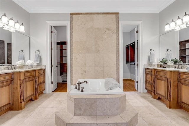 full bath featuring tile patterned floors, a whirlpool tub, two vanities, and crown molding