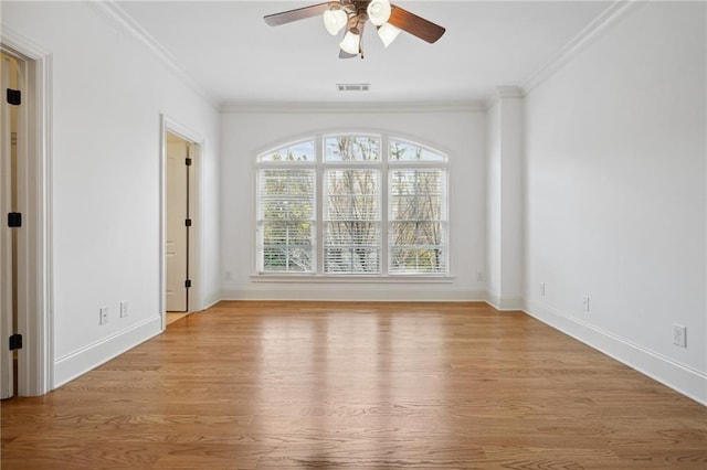 empty room with light wood-style flooring, baseboards, and ornamental molding