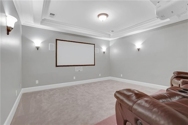 home theater room with a tray ceiling, light colored carpet, and visible vents