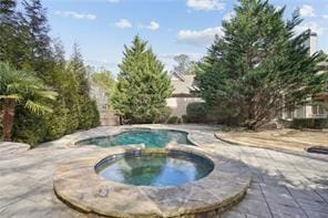 view of pool featuring an in ground hot tub