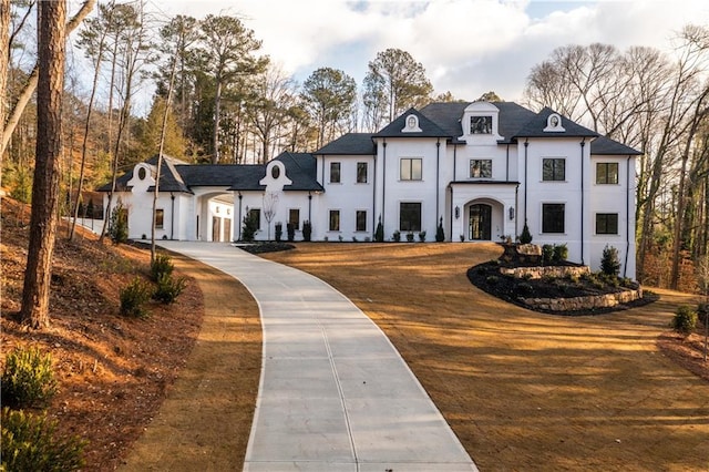 french country home with stucco siding