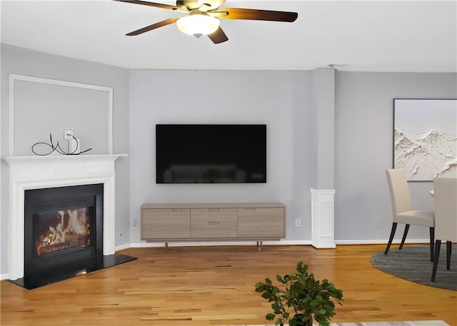1649 Southgate Mill Dr, Duluth, GA 30096 - living area with light wood-type flooring, ceiling fan, a glass covered fireplace, and baseboards