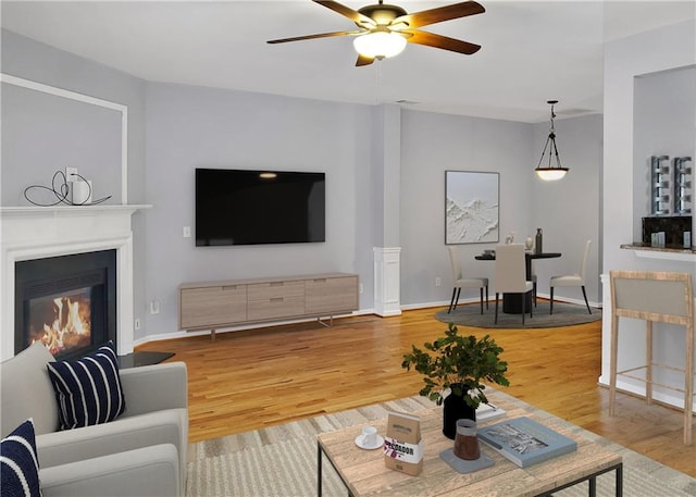 1649 Southgate Mill Dr, Duluth, GA 30096 - living room with wood finished floors, ceiling fan, a glass covered fireplace, and baseboards