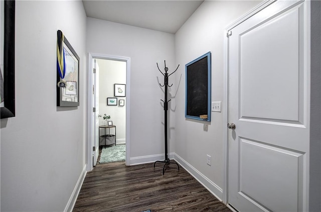 hall featuring baseboards and dark wood-style flooring