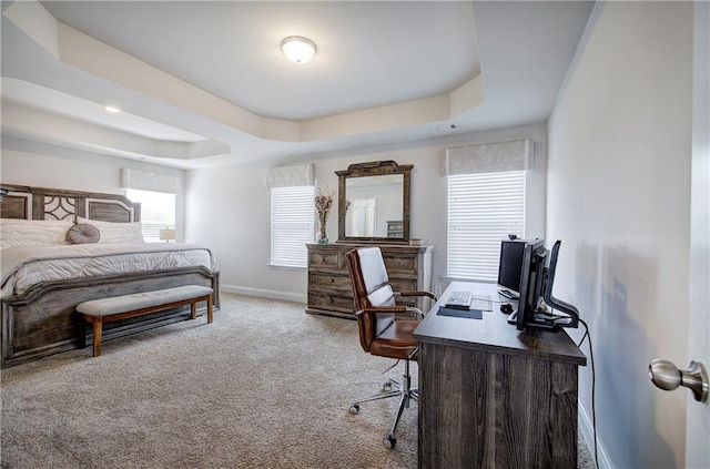 carpeted bedroom with baseboards and a tray ceiling