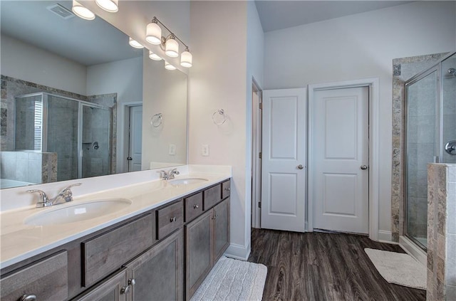 bathroom featuring a shower stall, wood finished floors, and a sink