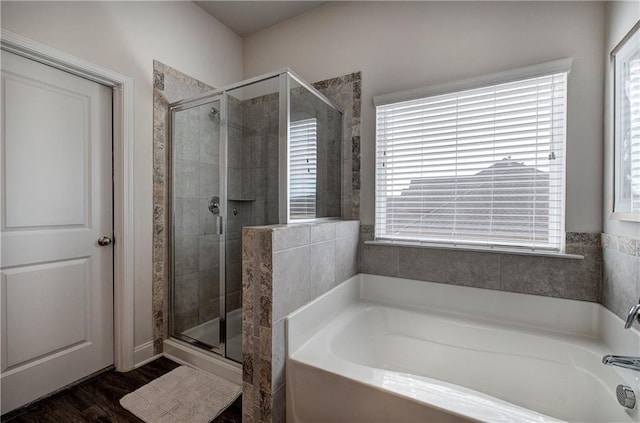 bathroom featuring a bath, wood finished floors, and a stall shower