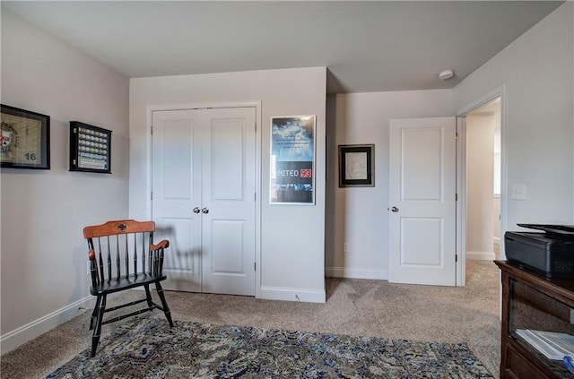 sitting room featuring carpet flooring and baseboards