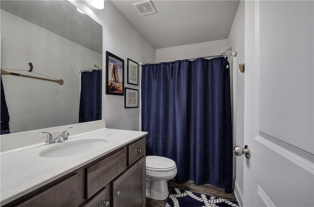 bathroom with visible vents, toilet, vanity, and a shower with curtain