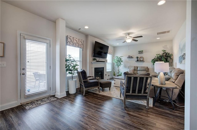 living area featuring wood finished floors, visible vents, recessed lighting, ceiling fan, and a glass covered fireplace