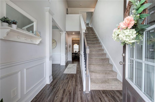 stairs featuring a decorative wall, wainscoting, and wood finished floors