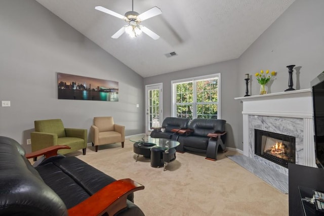 carpeted living room featuring ceiling fan, lofted ceiling, and a high end fireplace