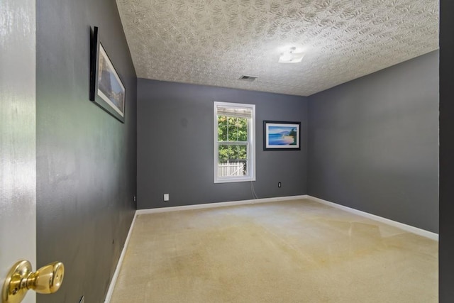 carpeted empty room with a textured ceiling