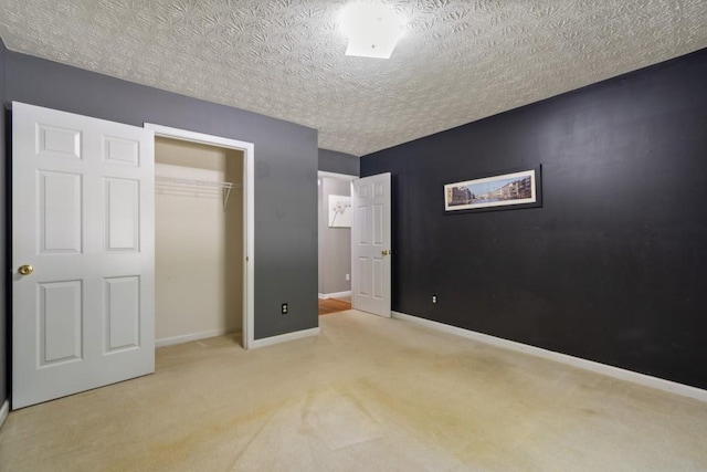 unfurnished bedroom with a closet, light carpet, and a textured ceiling