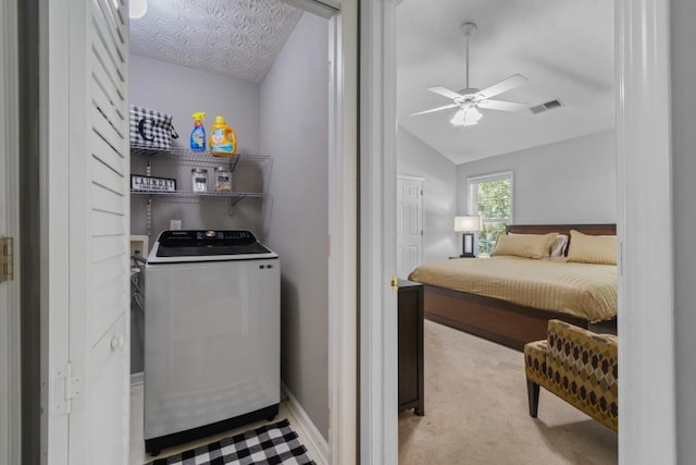 carpeted bedroom with vaulted ceiling, ceiling fan, a textured ceiling, and washer / clothes dryer