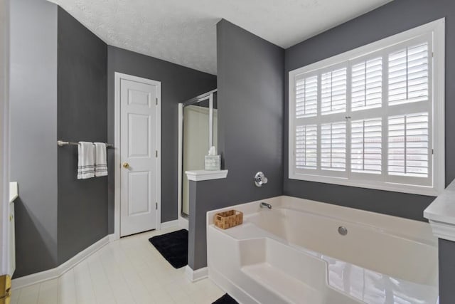 bathroom with a wealth of natural light, separate shower and tub, vanity, and a textured ceiling