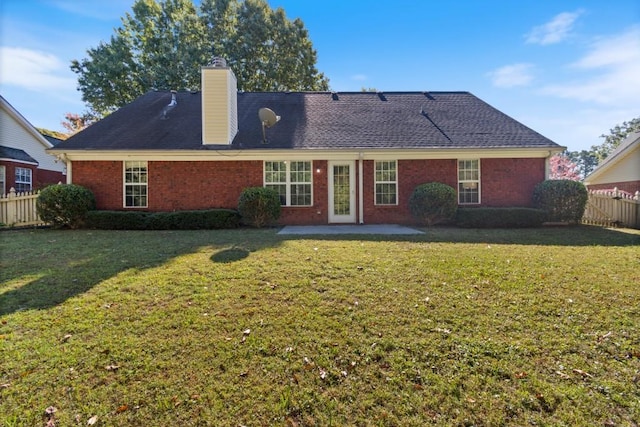 back of property with a patio area and a lawn